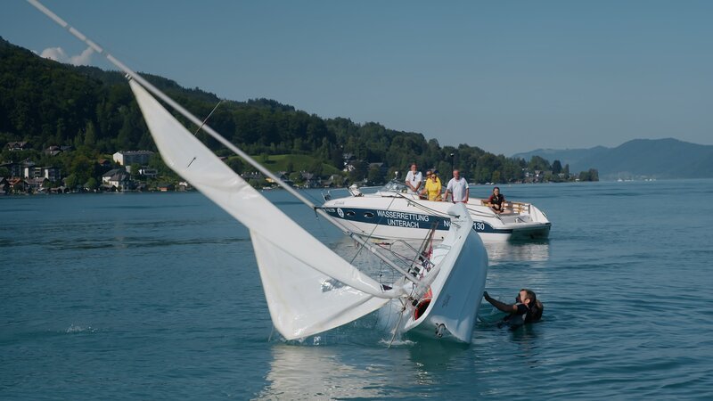 Mitglieder der Wasserrettung Unterach bei Bergung eines gekenterten Segelbootes – Bild: Südkino /​ ServusTV