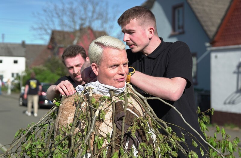 Guido Cantz wird von Jan Ritter (links) und Sven-Eric Ritter (rechts) das Quack-Kleid umgehangen. – Bild: MDR/​Lia Tesfazghi
