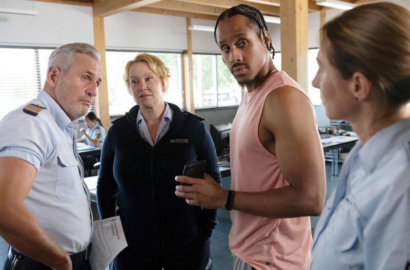 Paul Schott (Tim Wilde, l.) und Nele Fehrenbach (Floriane Daniel, 2.v.l.) nehmen die Vermisstenanzeige von Malte Hummert (Jonathan Kwesi Aikins, 2.v.r.) auf, dessen Freundin verschwunden ist. – Bild: ARD/​Laurent Trümper