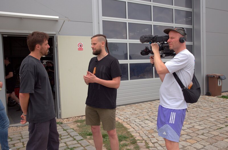 Reporter Frederik Fleig im Interview mit, Lukáš, einem Mitarbeiter von Piss-Up (Agentur für Junggesellenabschiede in Prag) und Kameramann Jonny Müller-Goldenstedt. – Bild: MDR/​Michal Novotný