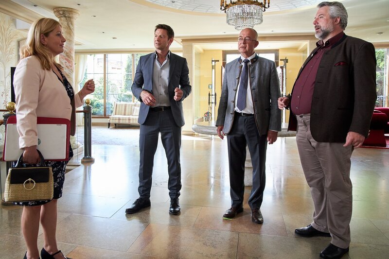 Polizeichef Achtziger (Alexander Duda, 2.v.r.) und Marie (Karin Thaler, l.) sind überrascht, die Kommissare Stadler (Dieter Fischer, r.) und Hansen (Igor Jeftić, 2.v.l.) dienstlich im Hotel Sonnenblick anzutreffen. – Bild: Bojan Ritan /​ ZDF