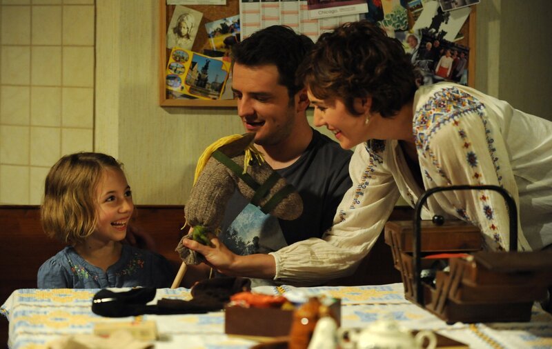 Flori hat es mit seinem Sockenpferdchen tatsächlich geschafft, Emma vom Fernseher wegzulocken. Von links: Emma Lechner (Anouk Lux), Florian Brunner (Tommy Schwimmer) und Fanny Lechner (Katrin Lux). – Bild: BR/​Marco Orlando Pichler
