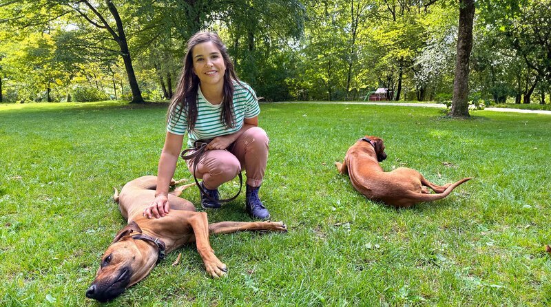 Anna im Park mit den Rhodesian Ridgebacks „Tiago“ und „Lysa“. – Bild: BR/​Text und Bild Medienproduktion GmbH & Co. KG/​Katja Schübl