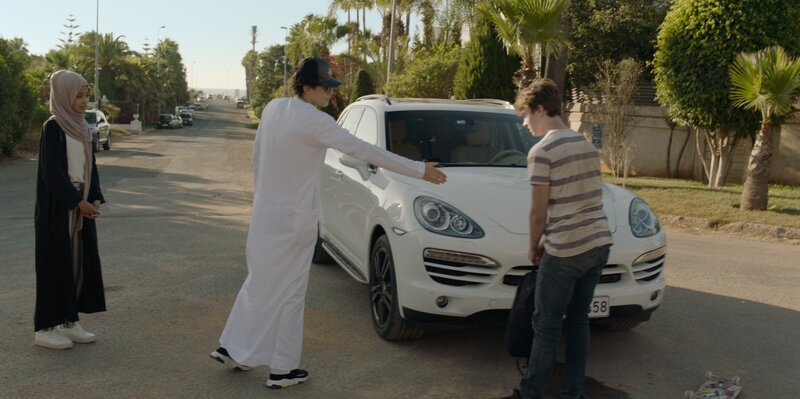 Zack (Thomas Chomel, r.) lernt bei einem Zusammenprall mit einem Porsche die Jugendlichen Moza (Razan Nassar, l.) und deren Bruder Salem (Zak Robertson, M.) kennen. – Bild: Eric Vernazobres /​ FTV /​ Storia /​ ZDF