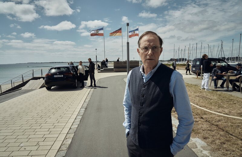 Thomas Haller (Stefan Kurt) steht auf der Straße, als seine Frau abgeführt wird. – Bild: ZDF und Thomas Leidig