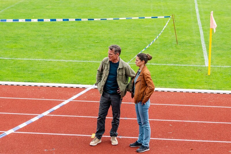 Matti Wagner (Pierre Besson, l.) berichtet Lilly Funke (Tatjana Kästel, r.) vom ermordeten Fußballspieler der Jugendmannschaft, die er trainiert. – Bild: Martin Rottenkolber /​ ZDF