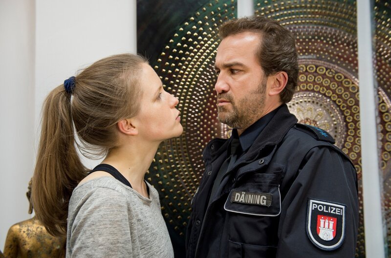 Paul Dänning (Jens Münchow, r.) will von Sylvia Havel (Julia Nachtmann, l.), der schwäbischen Besitzerin eines Yoga-Studios wissen, ob sie Frittenbudenbesitzer Curry-Kurti tatsächlich den Arm ausgekugelt hat. – Bild: ARD/​Thorsten Jander