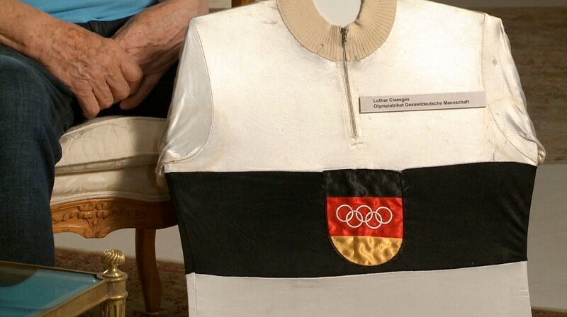 25 Jahre nach den Atombombenabwürfen in Japan finden 1964 die Olympischen Sommerspiele in Tokio statt. Mitten im Kalten Krieg sollen die Spiele zu einem Symbol für eine friedliche Welt werden. Insbesondere das geteilte Deutschland soll dies unter Beweis stellen: Auf Anordnung des IOC müssen beide deutsche Staaten trotz tiefer ideologischer Gräben mit einer gemeinsamen Mannschaft in Tokio antreten – Olympiatrikot Lothar Claesges. – Bild: rbb/​Zeitzeugen TV