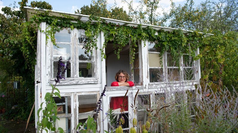 Zuerst geht es mitten nach Köln. Dort liegt die 300 Quadratmeter große Schrebergartenidylle von Gartenbloggerin Anja Klein. Ohne Strom, aber mit vielen bunten Blumen, einem aus gebrauchten Fenstern selbstgebauten Gewächshaus und Unmengen von Gemüse hat sich die 54jährige ein kleines Ökosystem geschaffen. – Bild: WDR/​Melanie Grande