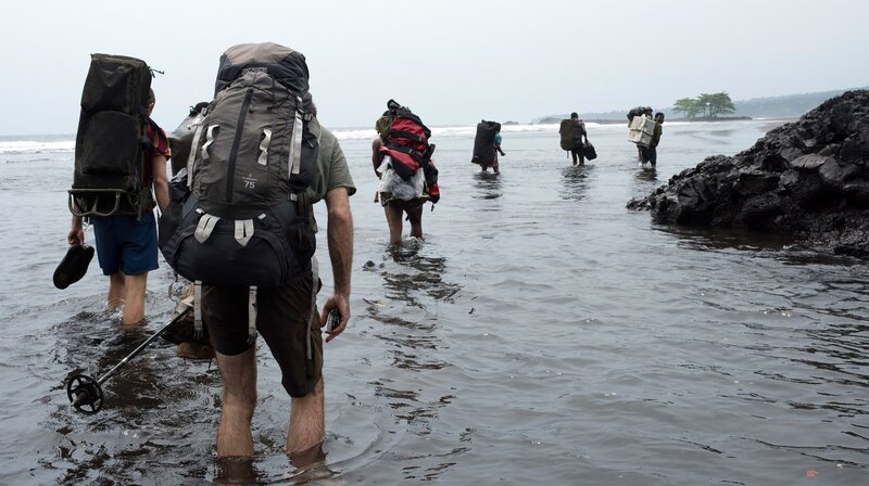Auf Bioko können viele Ziele nur zu Fuß entlang der Küste erreicht werden. Die Crew muss die gesamte Ausrüstung tragen. – Bild: NDR/​Doclights GmbH/​NDR Naturfilm/​Ivo Nörenberg