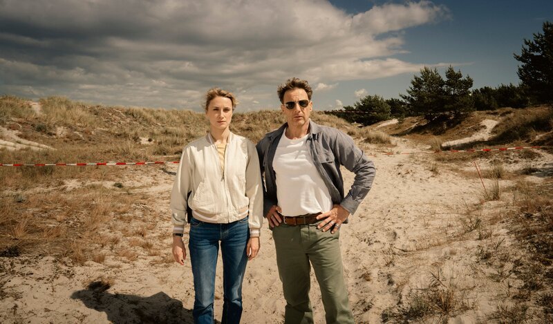 Tjark Wolf (Hendrik Duryn) und Femke Folkmer (Pia Barucki) in den Dünen.  +++ Die Verwendung des sendungsbezogenen Materials ist nur mit dem Hinweis und Verlinkung auf RTL+ gestattet. +++ – Bild: RTL /​ Christine Schroeder /​ MadeFor Film GmbH