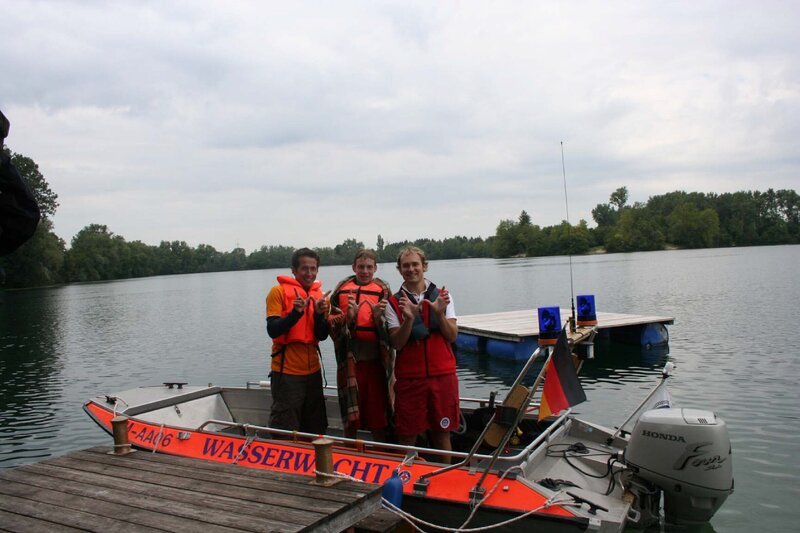 Willi mit den Wasserwachtlern Manfred und Matias am Langwieder See bei München. – Bild: BR/​megaherz