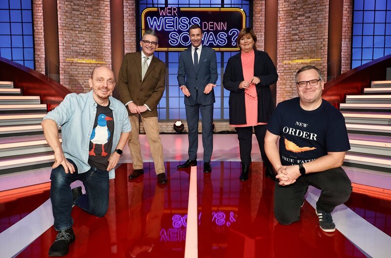 Moderator Kai Pflaume (M.) und seine Rateteam-Kapitäne Bernhard Hoëcker (l.) und Elton (r.) begrüßen in dieser Sendung die beiden ehemaligen „Zimmer Frei“-Moderator:innen: Den Musiker Götz Alsmann (2.v.l.) und die Fernseh- und Radiomoderatorin Christine Westermann (2.v.r.). – Bild: ARD/​Morris Mac Matzen