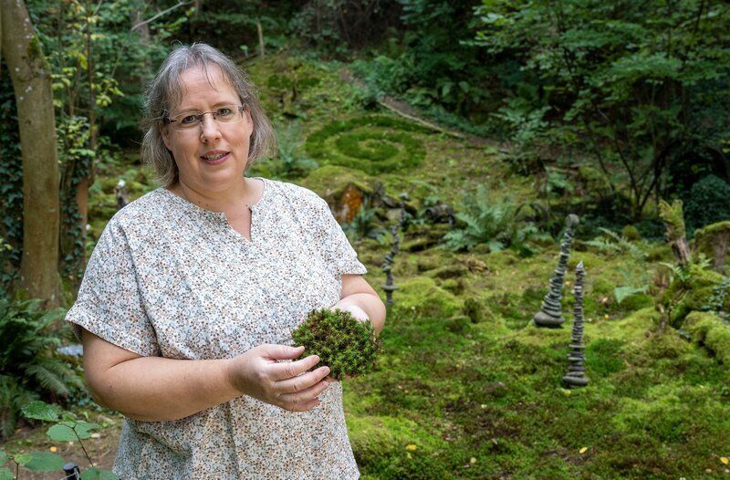 Ein ehemaliger Sandsteinbruch an der Nahe in Rheinland-Pfalz ist das Ziel der zweiten „Garten & lecker“- Reise. Dieses einst zugewucherte und unwegsame Gelände von acht Hektar haben die „Naturgärtner“ Ursula Altmoos (Foto) und ihr Mann Michael in 13 Jahren harter Arbeit in ein Wildgartenparadies verwandelt. Im schattigen Teil, am Steinhang, gedeihen auf rund 1000 Quadratmetern verschiedenste Moose und Farne. – Bild: WDR/​Melanie Grande