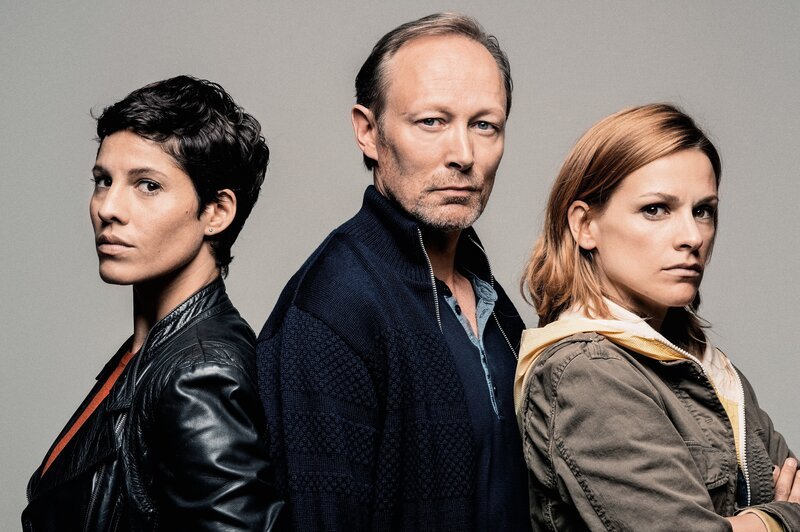 L-R: Jackie Mueller (Jasmin Gerat), Harald Bjørn (Lars Mikkelsen), Alicia Verbeek (Veerle Baetens) – Bild: Mathias Bothor /​ ORF /​ Networkmovie