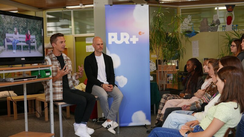 Wenn Menschen zusammenkommen, reden sie miteinander – auch wenn sie nicht sprechen. Sie kommunizieren über ihre Körpersprache. Im „PUR+“-Experiment versucht Moderator Eric Mayer (l.) zusammen mit dem Körpersprache-Experten Dirk Eilert (2.v.l) und einer Theater-AG herauszufinden, wie unser Körper unsere Gefühle verrät und welche Rolle unsere Sprache dabei spielt. – Bild: Ilka Wensing /​ ZDF
