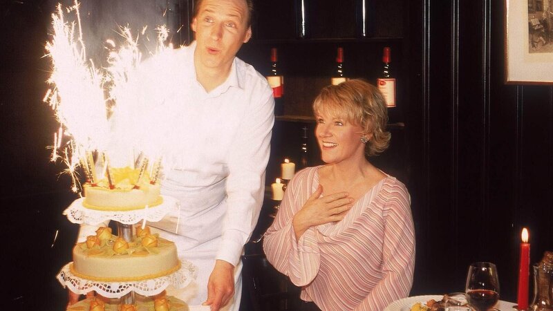 Kellner Ottmar bringt eine tolle Torte an Nikolas Tisch, die in dem Restaurant ganz allein ihren Geburtstag feiert. Doch leider ist die Torte nicht für sie. – Bild: MG RTL D /​ Guido Engels
