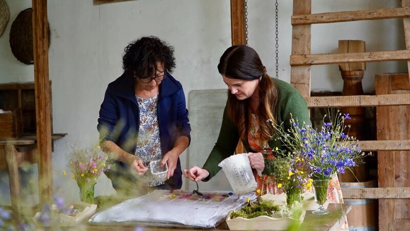 Moderatorin Conny Bürgler (rechts) gestaltet mit Margarethe Mörzinger (links) handgeschöpfte Lesezeichen mit Blumen – Bild: ServusTV / Degn Film / Barbara Meikl Moderatorin Conny Bürgler (rechts) gestaltet mit Margarethe Mörzinger (links) handgeschöpfte Lesezeichen mit Blumen – Bild: ServusTV / Degn Film / Barbara Meikl