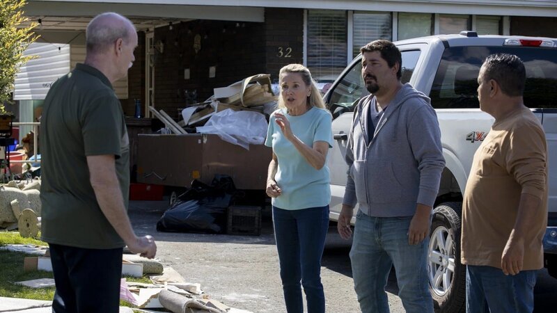 Mehrere Personen stehen vor einem Haus und diskutieren neben einem geparkten Pickup und einem Haufen Abfall. – Bild: The Movie Database (TMDb)