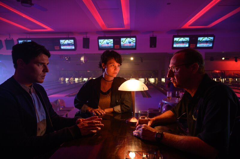 Die Teamleiterin der Bowlinggruppe von Wolfgang Matuschek (Mike Maas, r.) wurde ermordet. Alle scheinen tief betroffen zu sein. Doch Rico Sander (Benjamin Strecker, l.) und Polizeipraktikantin Nele Becker (Nina Siewert) glauben nicht, dass es in der Gruppe so harmonisch war, wie alle vorgeben. Vor allem seit Matuscheks Frau aufgrund eines Unfalls nicht mehr teilnehmen konnte. – Bild: MARKUS_FENCHEL /​ ZDF