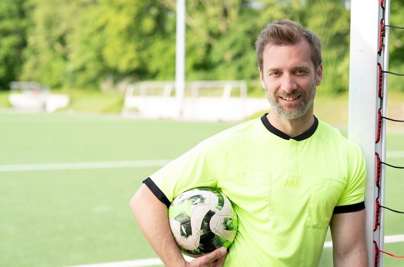 Für den Duisburger SV 1900 geht’s um den Aufstieg und Reporter Daniel Aßmann ist mittendrin. Beim Derby gegen den Mülheimer SV 07 begleitet er den Vereinsvorsitzenden, die Mannschaft und hat selbst einen Einsatz als Linienrichter. Dabei will er wissen, was die Faszination Amateurfußball ausmacht und was es braucht, damit hier Woche für Woche Fußball gespielt werden kann. – Bild: WDR /​ Solis TV /​ Melanie Grande