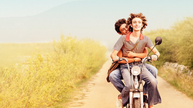 Key Visual/​Cover ohne Typo zu „Fireworks“. Sizilien, Sommer: Die Teenager Gianni (Samuele Segreto) und Nino (Gabriele Pizzuro) begegnen sich durch einen von Nino verursachten Moped-Unfall. Als Gianni bei Ninos Vater, einem Pyrotechniker, einen Job angeboten bekommt, gehört er schon bald zu Ninos Familie. Zwischen den Teenagern entwickelt sich eine zarte Liebe, die sie vergeblich versuchen, geheim zu halten. Bald werden sie zum Spott der konservativen Dorfgemeinschaft und massiv bedroht – sogar von ihren eigenen Familien. Im Bild: Die beiden Teenager Nino (Gabriele Pizzurro, vorne) und Gianni (Samuele Segreto, hinten) genießen auf Ninos Moped ihre Freiheit. – Bild: Salzgeber & Co. Medien GmbH