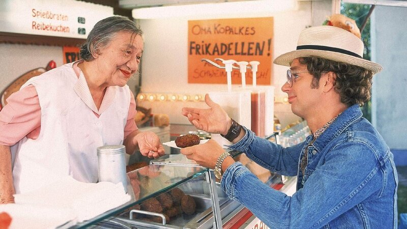 Atze (Atze Schröder) kauft bei Oma Kopalke (Dorothea Walda) eine ihrer Frikadellen – ein Beweisstück für seinen Rekordversuch. – Bild: RTL