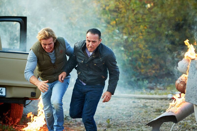 Morten flieht mit dem angeschlagenen Semir (Erdogan Atalay, r.) und crasht in einen Tank. Paul (Daniel Roesner) kann Semir in letzter Sekunde aus dem Wagen ziehen und in Sicherheit bringen bevor der Tank explodiert. – Bild: MG RTL D /​ Guido Engels
