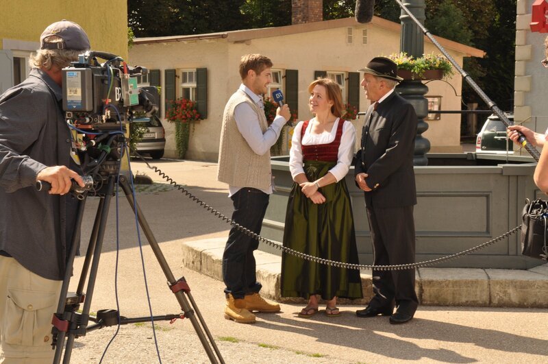 Für eine positive Darstellung Lansings im Fernsehen müssen sich Vroni und Schattenhofer am Riemen reißen. Von links: Gustl Niewand (Peter Foyse), Veronika Brunner (Senta Auth) und Lorenz Schattenhofer (Werner Rom). – Bild: BR/​Jo Bischoff