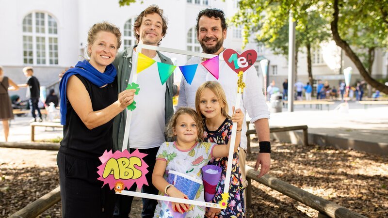 Checker Tobi bei der Einschulungsfeier mit den Schülerinnen Luna und Maya und ihren Eltern Cecilia und Andre. – Bild: BR/​mgeaherz GmbH/​Hans-Florian Hopfner