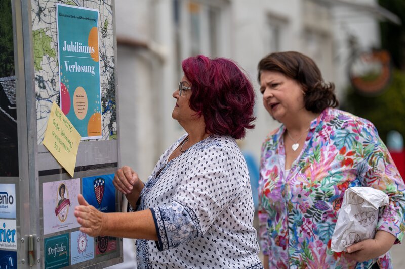 Monika (Christine Reimer, rechts) hofft, bei Gundis (Helga Januschkowetz, KLD, links) Kiosk-Verlosung unter den glücklichen Gewinnern zu sein. – Bild: Ewa Wiese /​ BR