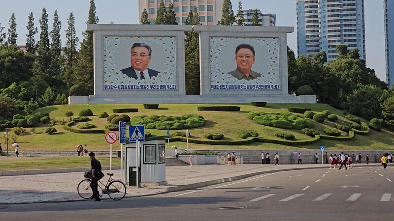 Plakatwände mit Darstellungen von Kim Il Sung und Kim Jong Il auf einer Straße in North Korea. – Bild: RTL