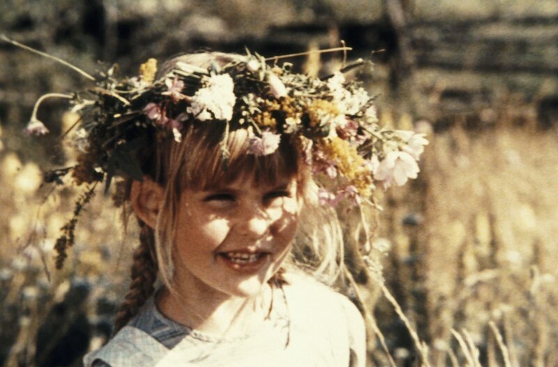 Ida (Lena Wisborg) amüsiert sich mit ihrem Blumenkranz auf dem Kopf und bemerkt, wie ruhig es plötzlich ohne Michel ist. – Bild: ZDF/​Svensk Film