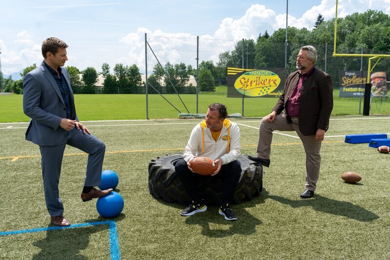 Marcel Tews (Stefan Wilkening, M.), der Geschäftsführer des Footballvereins, schildert den Kommissaren Hansen (Igor Jeftić, l.) und Stadler (Dieter Fischer, r.), wie er den toten Quarterback vorgefunden hat. – Bild: Linda Gschwentner /​ ZDF