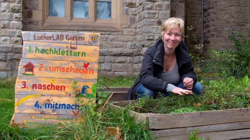 Zum Finale geht es nach Bochum in einen noch jungen Gemeinschaftsgarten. Seit zwei Jahren gärtnert Hannah Brack gemeinsam mit anderen auf dem Gelände rund um eine entweihte Kirche. Es wurden Beete angelegt, Beerenobst gepflanzt, insektenfreundliche Blumenwiesen ausgesät und aus Holzpaletten Sitzmöbel gebaut. Der Garten steht allen Nachbarn offen und soll zum Mitmachen animieren. – Bild: WDR/​Melanie Grande