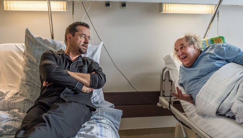 Prof. Boerne’s Klinik-Zimmernachbar Ulrich Göbel (Josef Ostendorf, r) hört am liebsten Schlager und ist auch sonst recht redselig. Interessant findet Prof. Boerne (Jan Josef Liefers), dass Göbel keine Nebenwirkungen durch die Einnahme der Medikamente gegen seine Krebskrankheit spürt. – Bild: WDR/​Filmpool Fiction/​Wolfgang Ennenbach