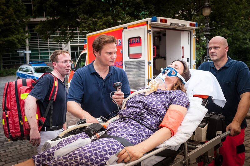 Dr. Haase (Fabian Harloff, 2.v.l.) macht sich Sorgen. Er hat bei seiner Patientin (Elisabeth Baulitz) eine schwere allergische Schockreaktion diagnostiziert, doch ist noch unklar, worauf sie so stark reagiert hat. – Bild: ZDF/​Boris Laewen