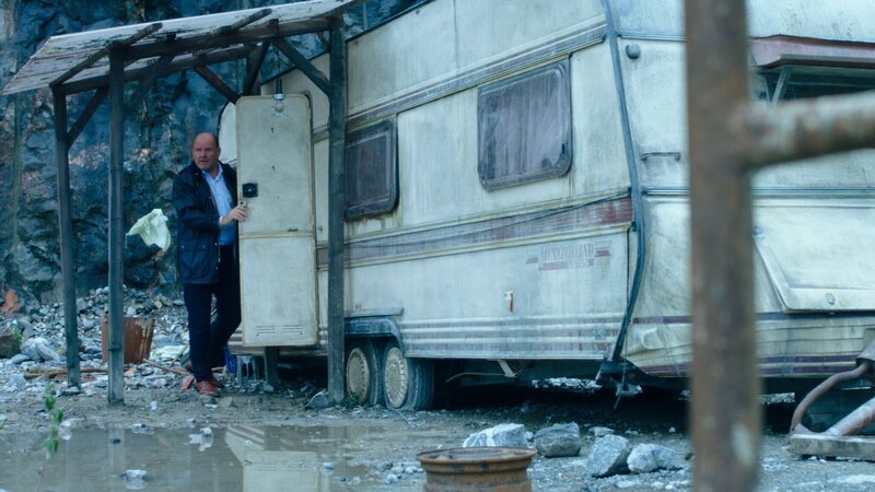 Ernst Geschwendner (August Schmölzer) untersucht im Alleingang einen baufälligen Wohnwagen im Steinbruch. – Bild: ZDF/​Petro Domenigg