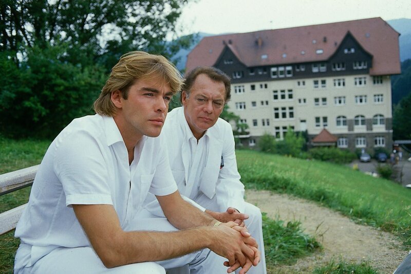Dr. Udo Brinkmann (Sascha Hehn) macht sich große Sorgen um Claudia und findet Trost bei seinem Vater (Klausjürgen Wussow). – Bild: ZDF und Thomas Waldhelm