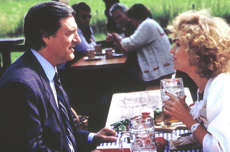 Im Biergarten ahnt Ilse (Ilse Neubauer) noch nicht, dass ihr Josef (Helmut Fischer) begonnen hat, über sein Testament nachzudenken. – Bild: BR/​Tatiana Film GmbH & Co. Audio KG