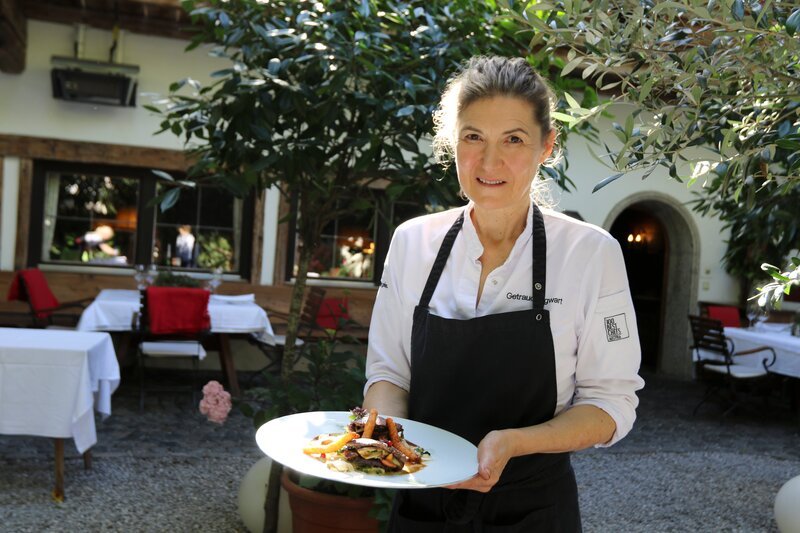 Portrait halbnah von Haubenkoechin Traudi Sigwart mit Wildgerichtwährend ServusTVs „Höchster Genuss im Alpbachtal“ im Haubenrestaurant „Sigwarts Tiroler Weinstuben „in Brixlegg, Tirol, Österreich am 28.09.2023 – Bild: ServusTV /​ Terra Mater