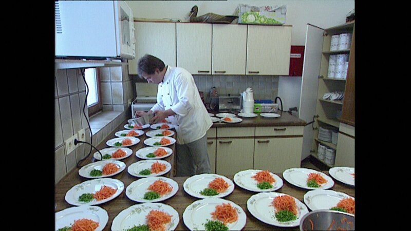 1995: Schroth-Kur in Oberstaufen. Karges Essen dominiert den Alltag. Im Bild: der Koch richtet das Abendessen an, d.h. rohe, geraspelte Karotten und kleingehackte Kräuter. – Bild: NDR /​ BR