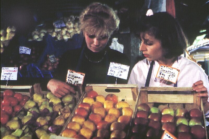 Standlfrau auf dem Viktualienmarkt zu sein, ist doch nicht so einfach, wie sich das Christa (Bettina Redlich, rechts) vorgestellt hat. Den vielen Dingen, die ihr ihre Kollegin (N.N.) erzählt, kann sie kaum folgen … – Bild: BR/​Tatiana Film GmbH & Co. Audio KG
