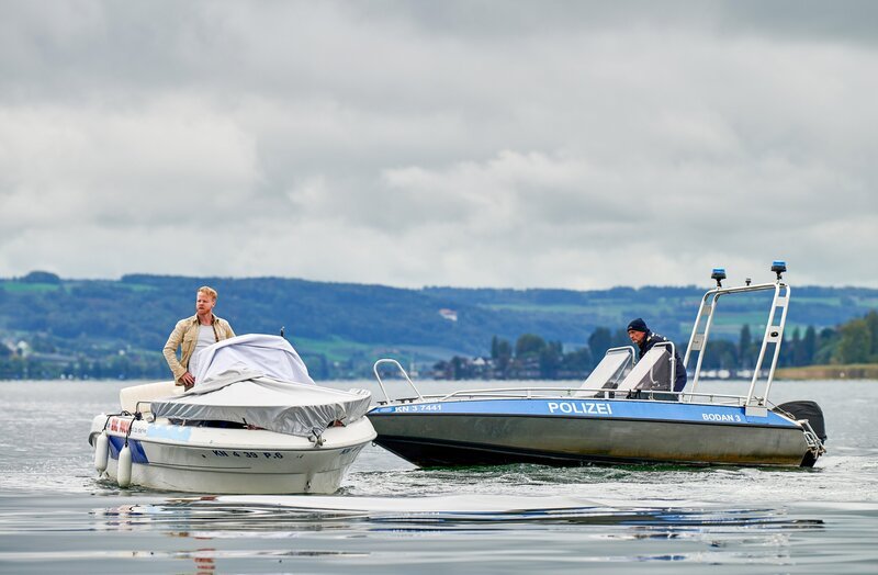 Paul Schott (Tim Wilde, r.) stellt Mikey Radny (Martin Wißner, l.) nach einer Verfolgungsfahrt auf dem Bodensee, weil der versucht hatte sich einem Verhör zu entziehen. – Bild: ORF/​Bavaria/​ARD/​Nicolas Gradicsky
