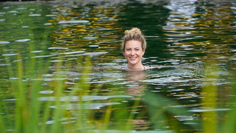 Heimatleuchten Moderatorin Sarah Pernerstetter im Badeteich der Alpentherme Bad Hofgastein – Bild: Lena Moik /​ ServusTV /​ Degn Film