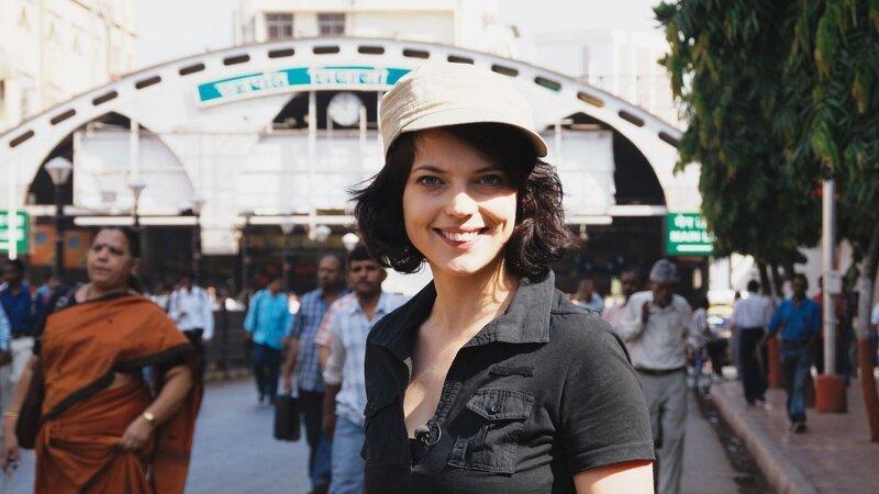 Mona Vetsch vor dem Seiteneingang des Victoria Terminus in Mumbai. – Bild: Honorarfrei – nur für diese Sendung inkl. SocialMedia bei Nennung ZDF und SRF/​Markus Storrer.