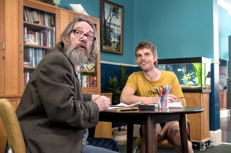 Der von Trevor (Harry Greenwood, re.) wiederholt gespielte Song „Come On Eileen“ setzt sich in Niks Kopf fest und verschlimmert seine psychische Verfassung. – Bild: BBC Studios
