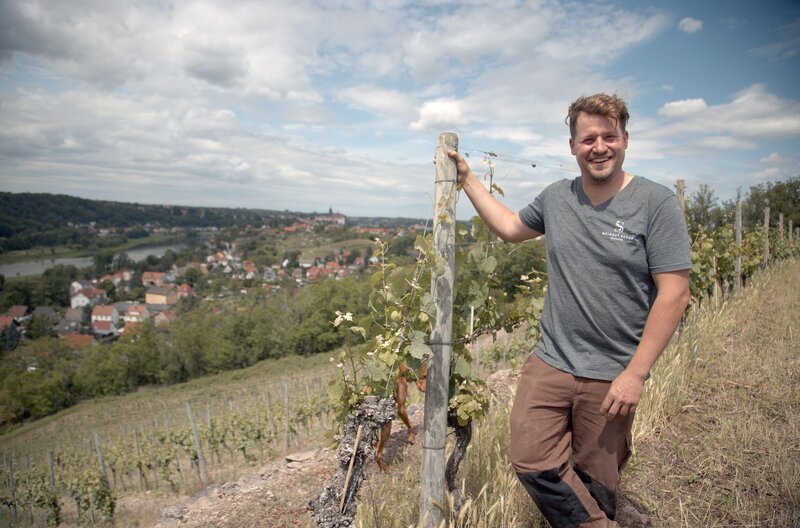 Winzer Matthias Schuh auf seinem Weinberg hoch über der Elbe. Entlang des Elbufers schlängelt sich die sächsische Weinstraße, eines der kleinsten und ältesten Weinanbaugebiete Deutschlands. – Bild: Björn Lindenblatt/​doc.station