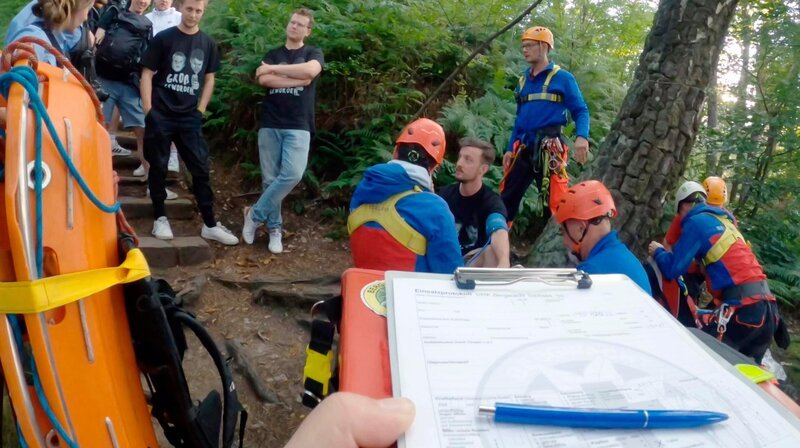 Das Team Sebnitz wird zu einem Junggesellenabschied gerufen. Ein alkoholisierter Wanderer ist gestürzt und war bewusstlos. Die Bergretter versuchen ihn ins Krankenhaus zu bringen. Doch dort will er um keinen Preis hin. Ob ihn Sanitäter Florian noch überzeugen kann? Am Amselsee in Rathen erleidet ein Mann nach einem Insektenstich einen allergischen Schock. – Bild: MDR/​Mia Media