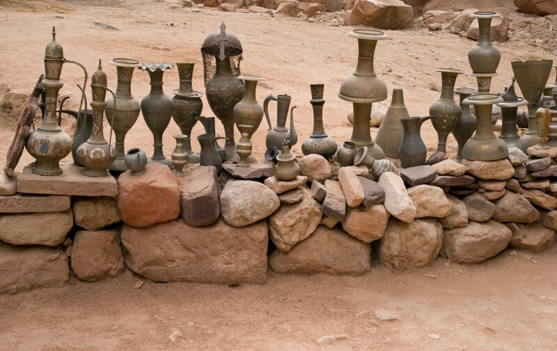 Alte Töpfe, die zum Verkauf stehen, sind auf einem Steinhaufen ausgestellt. Petra, Jordanien. – Bild: Getty Images /​ iStockphoto